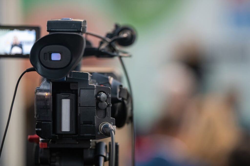 Behind the scenes, a media camera capturing the captivating moments of a dynamic event.